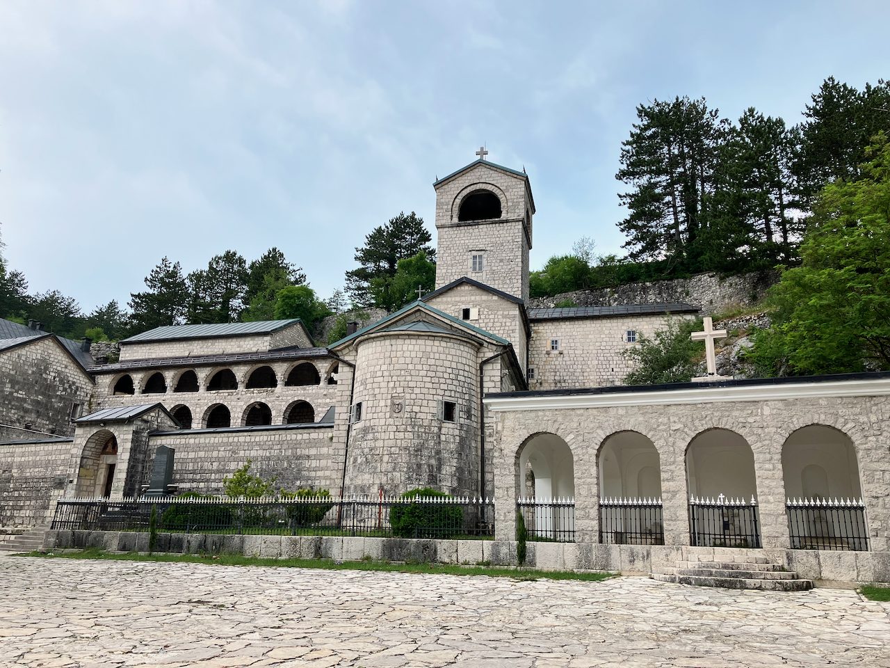 A historic Orthodox monastery set against wooded hills
