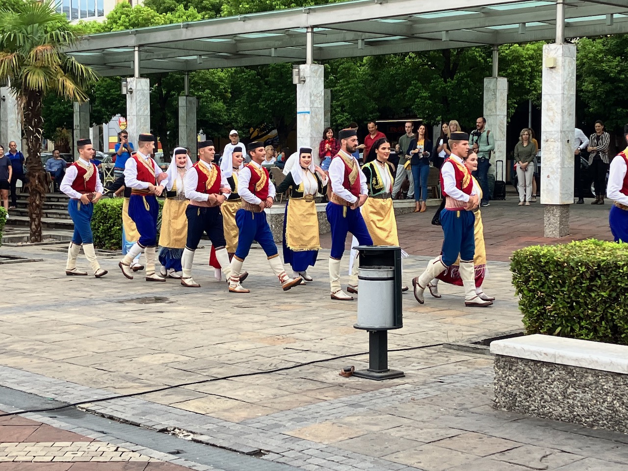 A group in traditional Montenegrin dress performing a folk dance in a public square