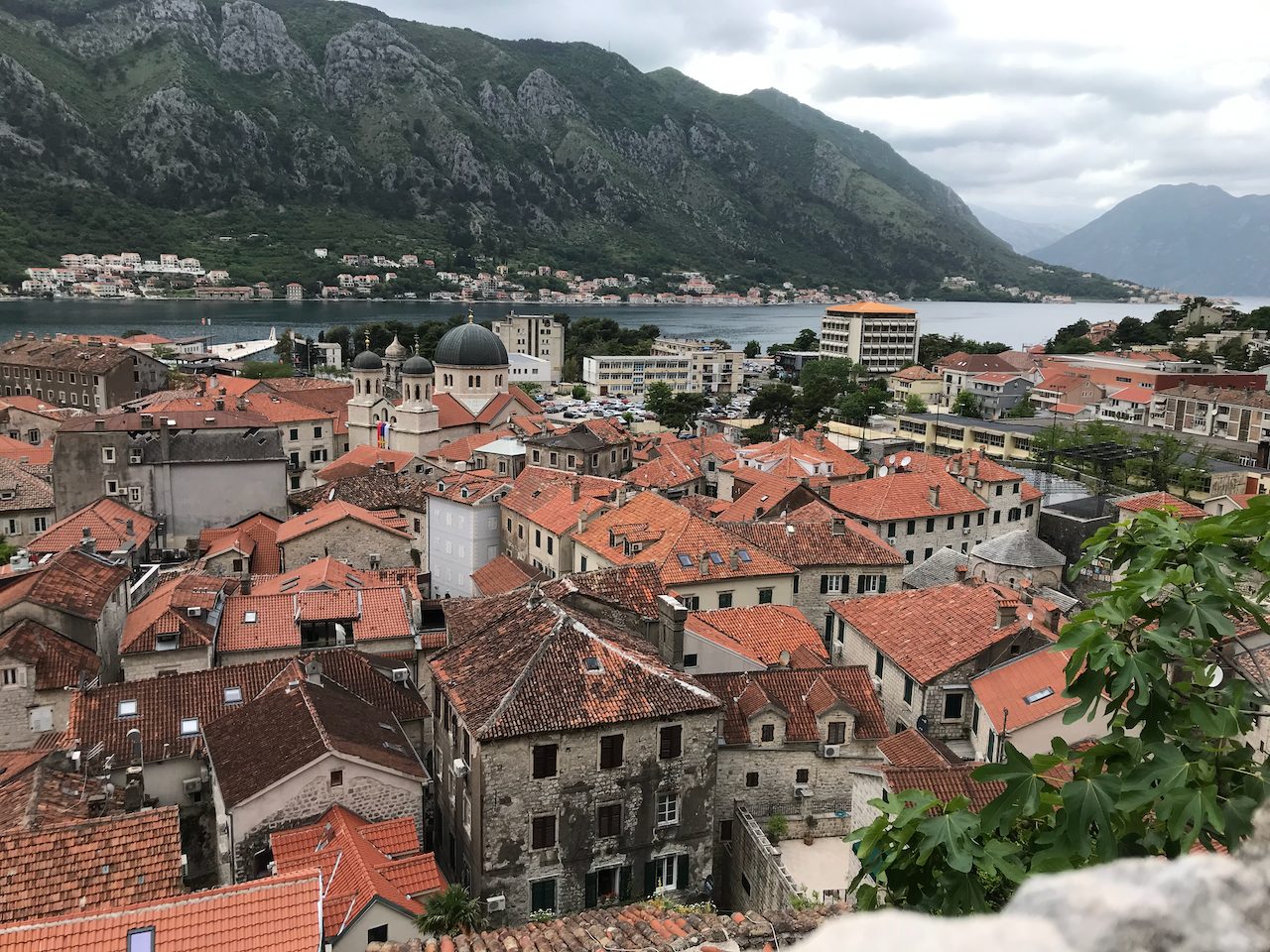 Red-tiled rooftops of a Montenegrin coastal town beneath steep mountains