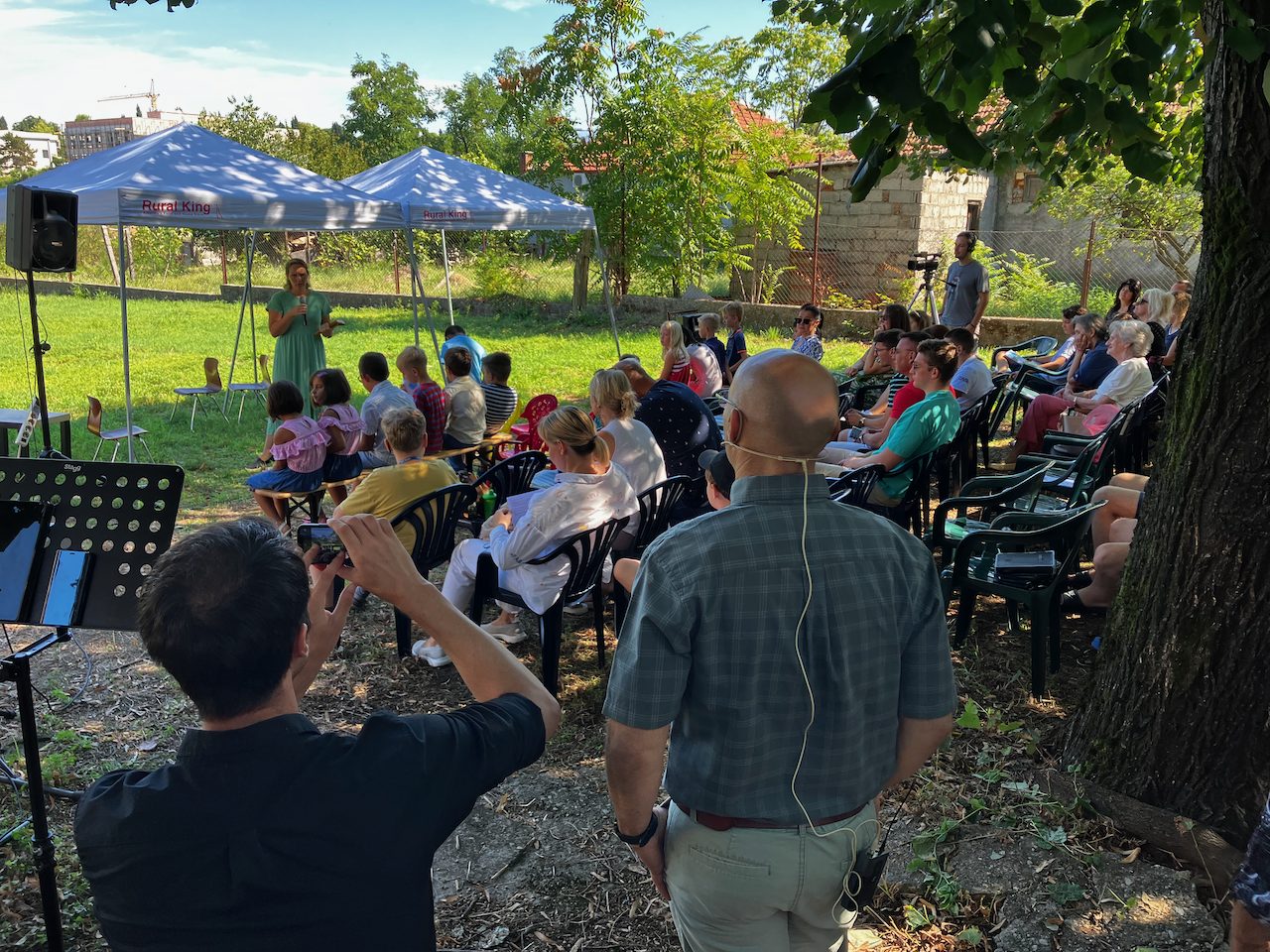 A man teaching a gathered group outdoors