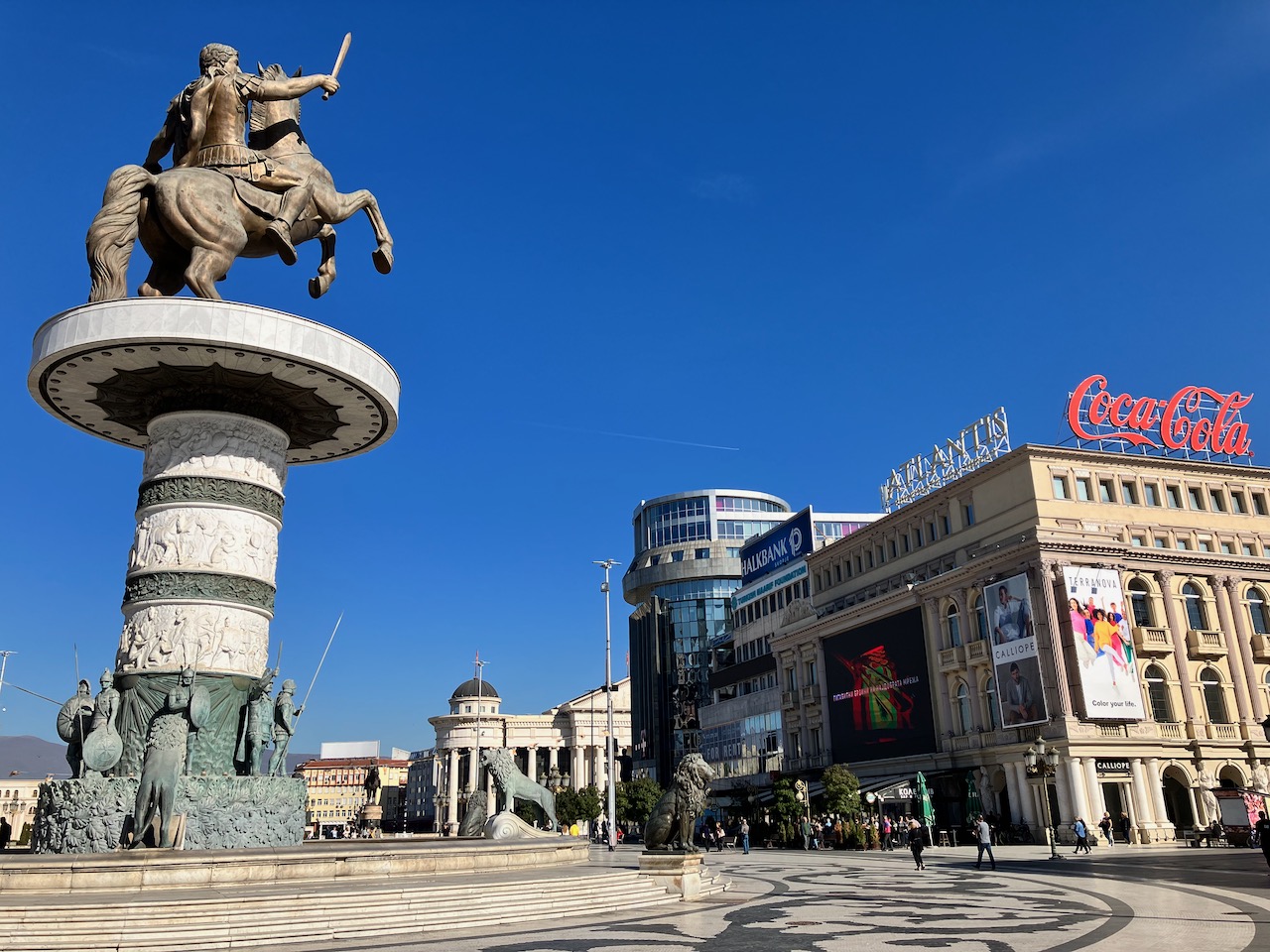 A grand city square with an equestrian statue and surrounding storefronts
