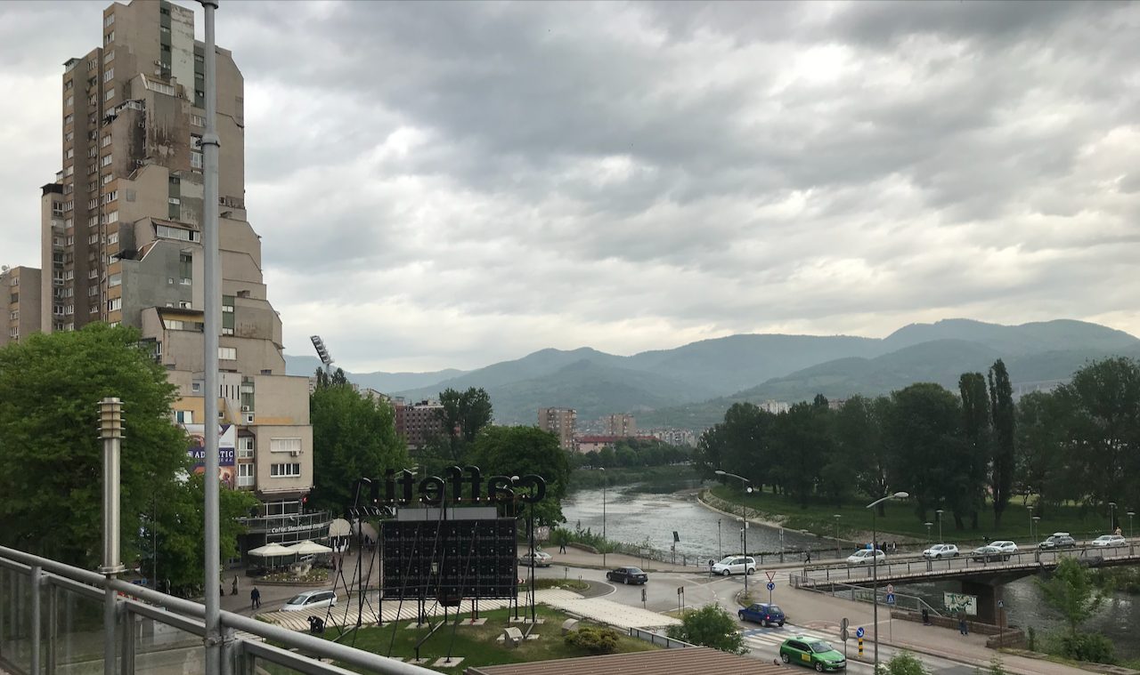 A river running past apartment blocks in a Bosnian city